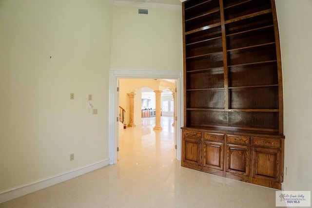 corridor featuring crown molding and decorative columns