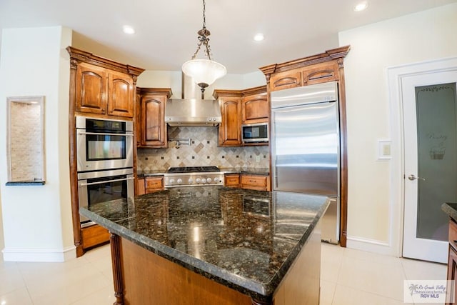 kitchen featuring backsplash, hanging light fixtures, a kitchen island, and stainless steel appliances