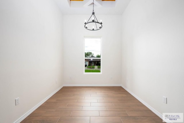 unfurnished room featuring a chandelier and hardwood / wood-style flooring