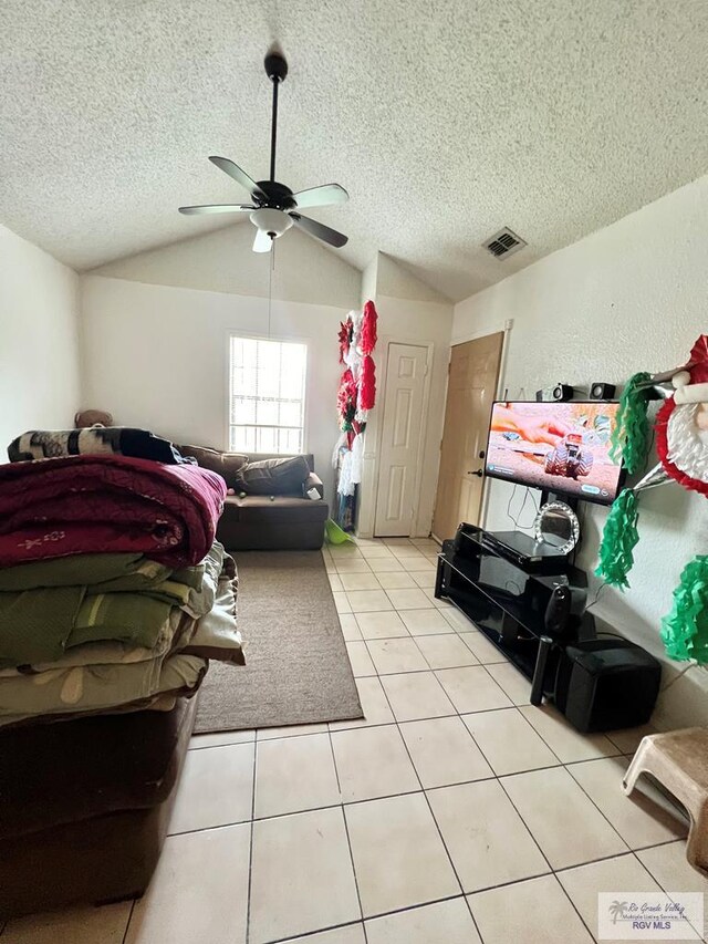 tiled living room with ceiling fan, lofted ceiling, and a textured ceiling