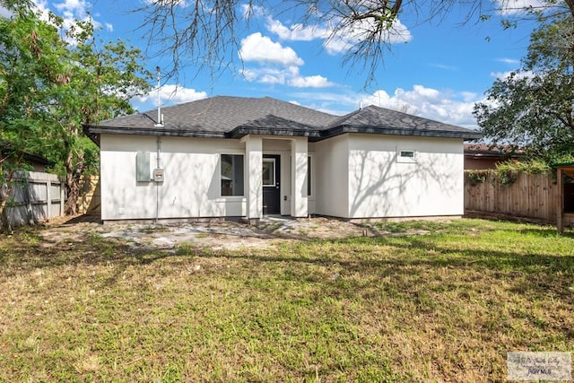 rear view of property with a yard, roof with shingles, and fence private yard