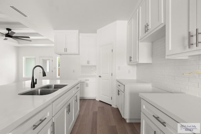 kitchen featuring light countertops, white cabinetry, a sink, and visible vents