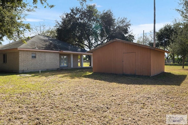 back of house featuring a yard and a storage shed