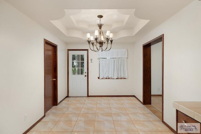 interior space with a notable chandelier and a tray ceiling