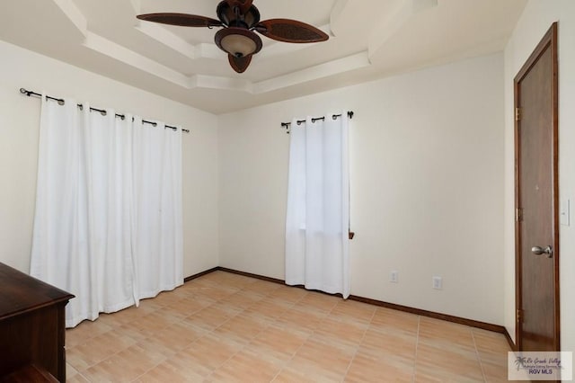 unfurnished bedroom featuring a raised ceiling and ceiling fan