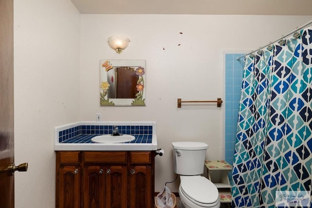 bathroom featuring toilet, a shower with shower curtain, and vanity