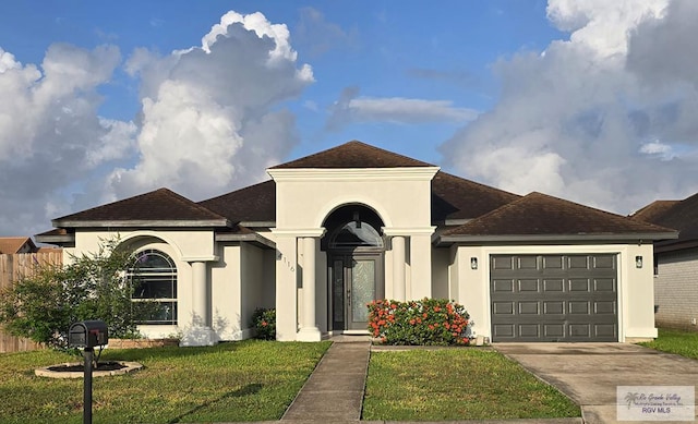 4116 Yoli Ln, Brownsville, TX 78521 - view of front facade featuring a front lawn, an attached garage, driveway, and stucco siding