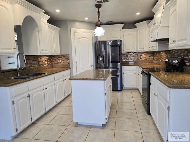 4116 Yoli Ln, Brownsville, TX 78521 - kitchen featuring stainless steel fridge, black electric range oven, custom range hood, decorative backsplash, and recessed lighting
