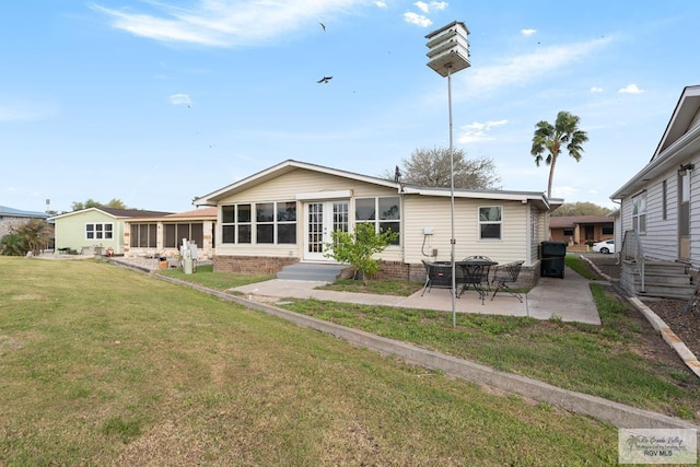 2029 W Michigan Dr, Harlingen, TX 78550 - back of house with entry steps, a patio, a lawn, and a sunroom