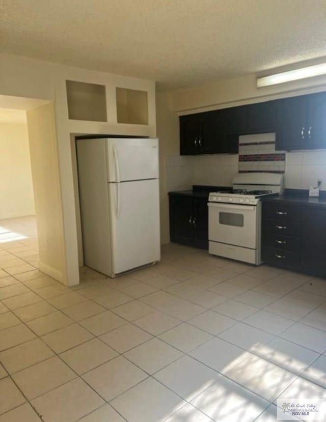 kitchen featuring a textured ceiling, white appliances, and light tile patterned flooring