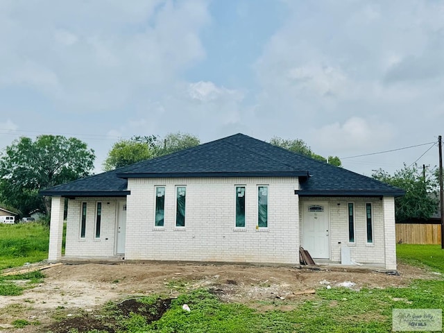107 Willacy Ave, Brownsville, TX 78521 - rear view of house featuring roof with shingles, fence, and brick siding