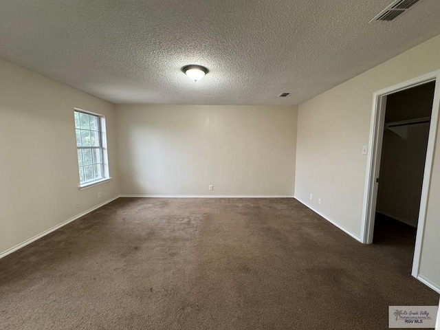 1072 Vamonos Dr, Brownsville, TX 78526 - empty room with dark colored carpet and a textured ceiling