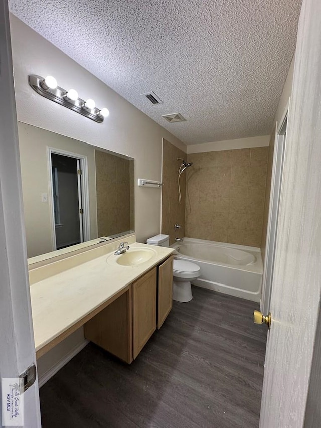 1072 Vamonos Dr, Brownsville, TX 78526 - bathroom featuring vanity, wood finished floors, a textured ceiling, and bathtub / shower combination
