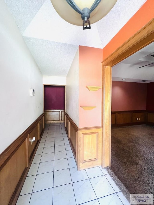 4407 Alejandro St, Mission, TX 78573 - hall featuring a wainscoted wall, a textured ceiling, and light tile patterned flooring
