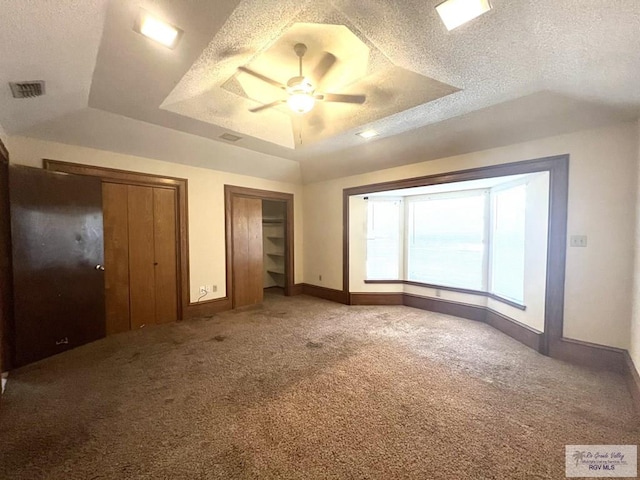 4407 Alejandro St, Mission, TX 78573 - unfurnished bedroom with a raised ceiling, carpet flooring, two closets, baseboards, and a textured ceiling
