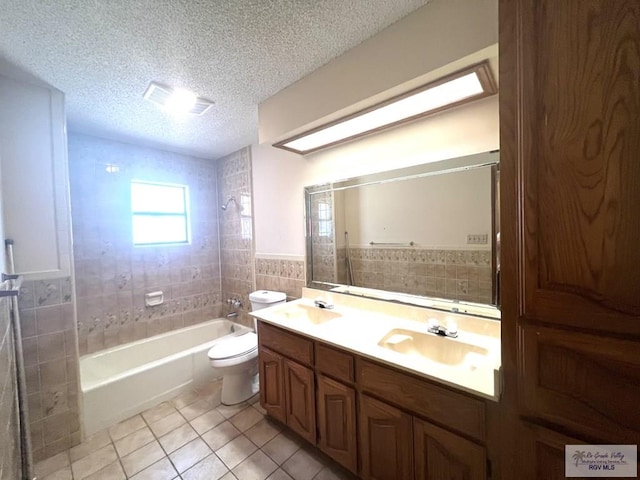 4407 Alejandro St, Mission, TX 78573 - bathroom featuring tile patterned floors, a textured ceiling, toilet, tile walls, and shower / washtub combination