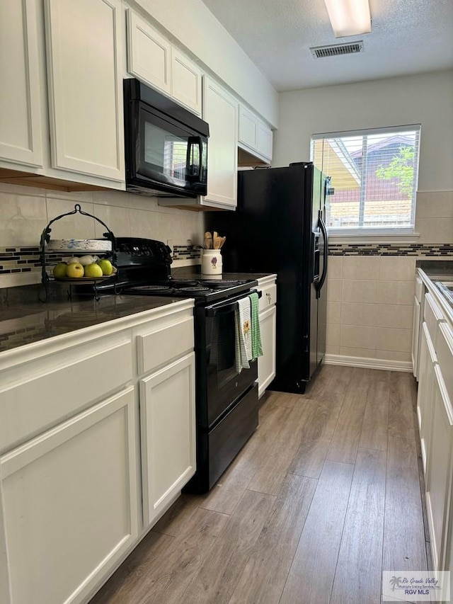 kitchen featuring white cabinetry, black appliances, and light hardwood / wood-style floors