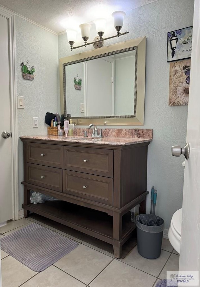 bathroom featuring tile patterned floors, vanity, a textured ceiling, and toilet