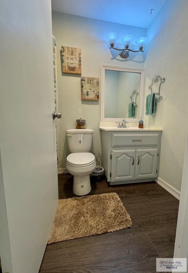 bathroom featuring hardwood / wood-style floors, vanity, and toilet