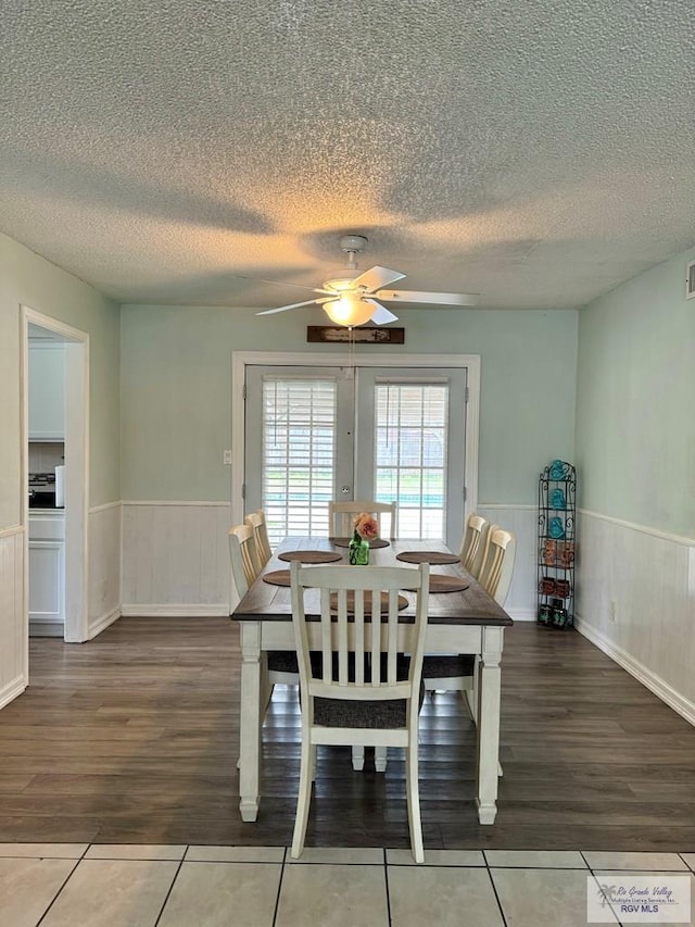 dining space with ceiling fan, wood-type flooring, a textured ceiling, and french doors