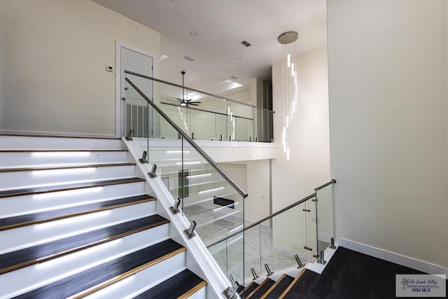 staircase featuring ceiling fan