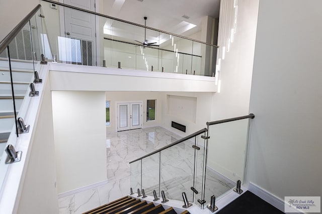 stairs with french doors and ceiling fan