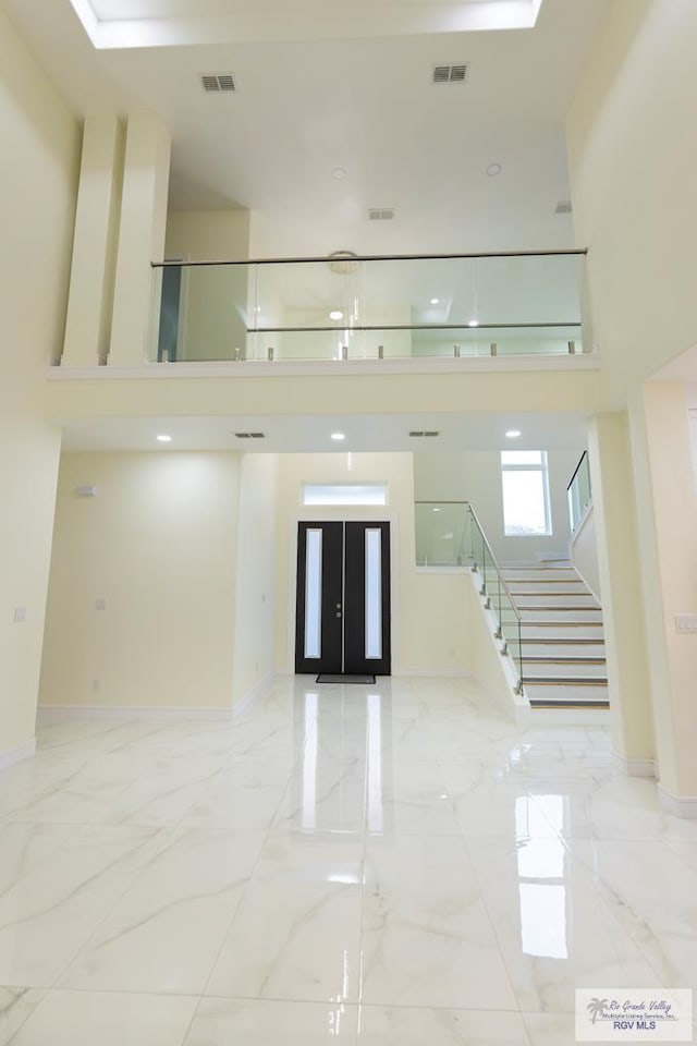 interior space featuring french doors and a towering ceiling