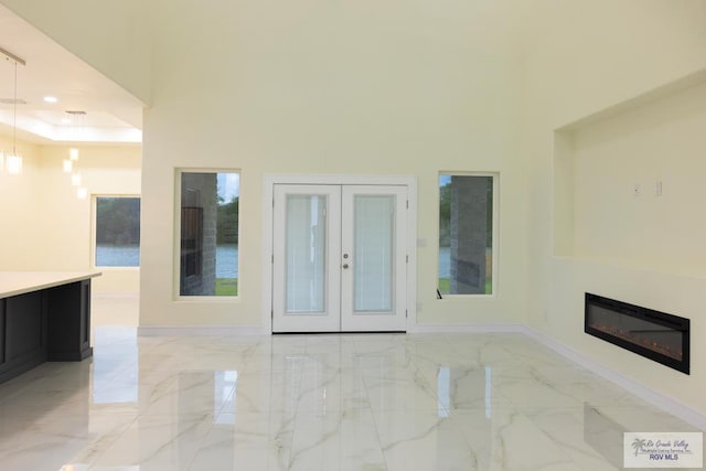 unfurnished living room featuring french doors and a high ceiling