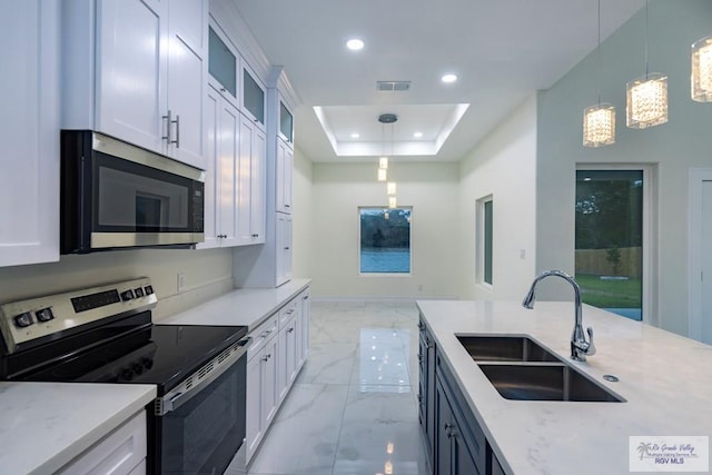 kitchen with stainless steel appliances, hanging light fixtures, sink, and white cabinets