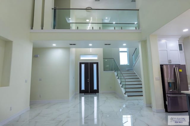 entrance foyer with french doors and a high ceiling