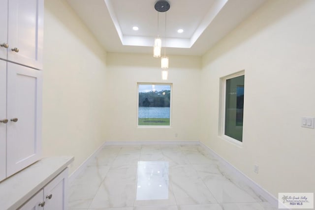 unfurnished room featuring a raised ceiling