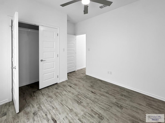 unfurnished bedroom with a closet, hardwood / wood-style flooring, and ceiling fan