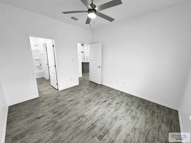 unfurnished bedroom featuring ceiling fan, dark hardwood / wood-style floors, and a spacious closet