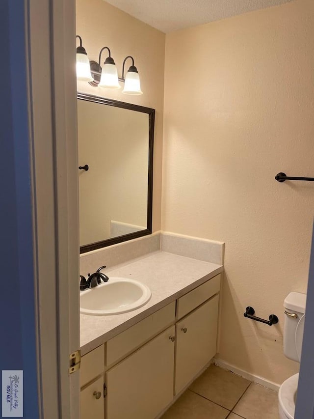 bathroom featuring tile patterned floors, vanity, a textured ceiling, and toilet