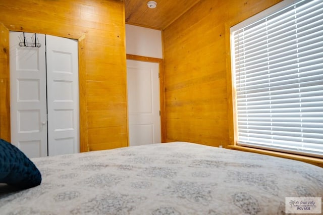 unfurnished bedroom featuring wooden walls and a closet