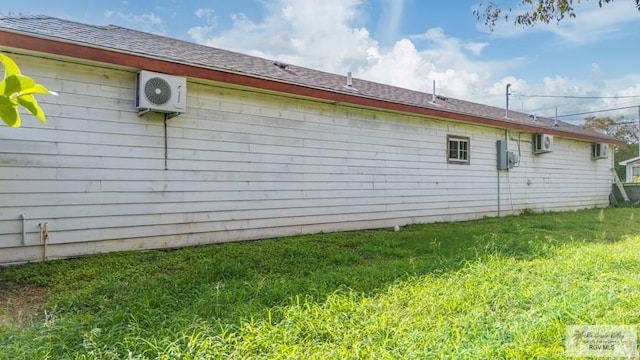 view of side of home featuring an AC wall unit, ac unit, and a lawn