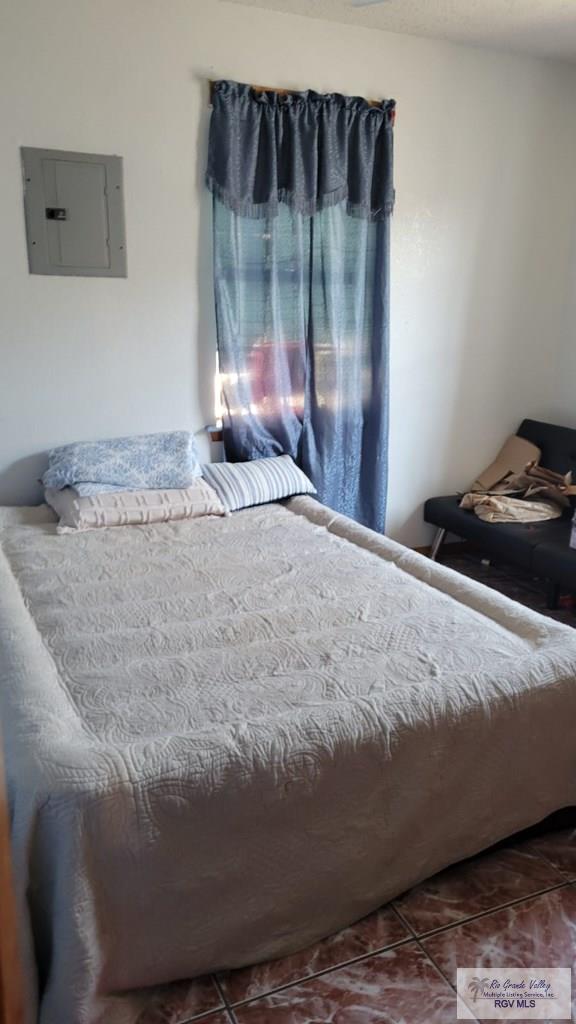 bedroom featuring electric panel and tile patterned floors