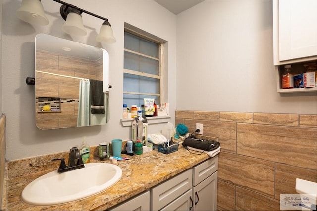 bathroom with vanity, tile walls, and walk in shower