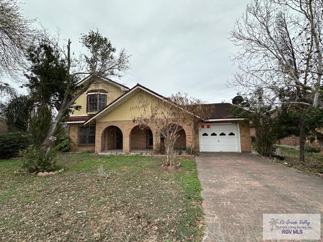 view of front of home with a garage and a front lawn