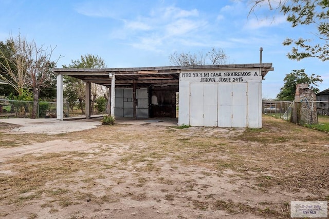 view of outbuilding with fence and an outdoor structure