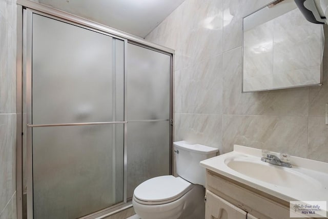 bathroom featuring a stall shower, toilet, tile walls, and vanity