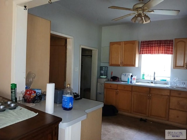 609 E Filmore Ave, Harlingen, TX 78550 - kitchen featuring a ceiling fan, light countertops, a peninsula, light tile patterned floors, and brown cabinets