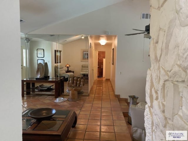 corridor with tile patterned floors and lofted ceiling