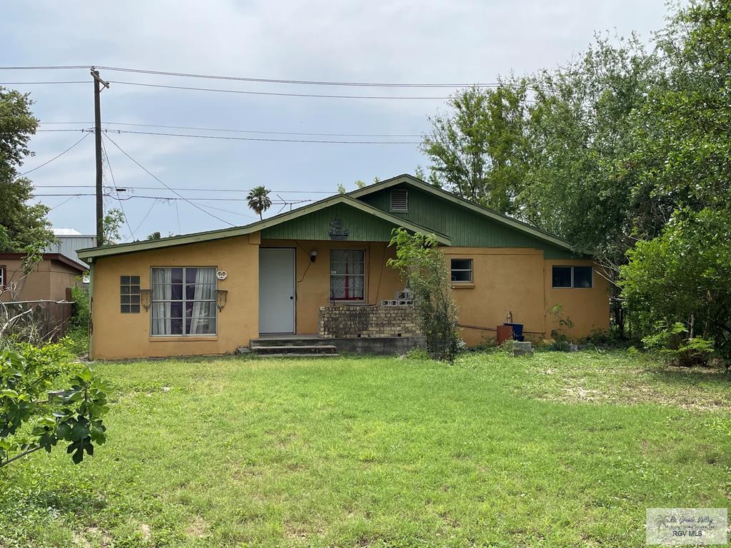 single story home with stucco siding and a front lawn