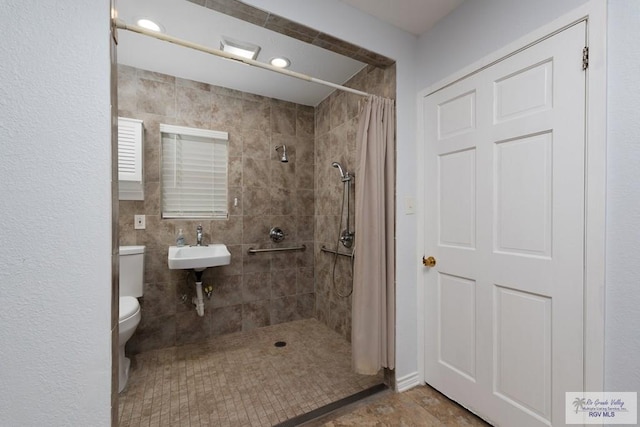 bathroom featuring a shower with curtain, sink, tile walls, and toilet