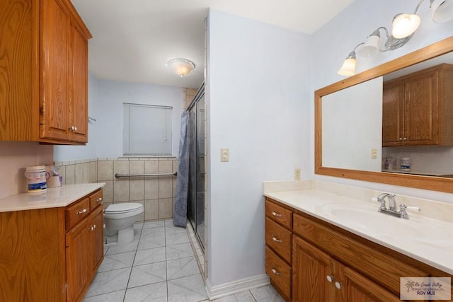 bathroom with a shower with shower curtain, vanity, tile walls, tile patterned flooring, and toilet