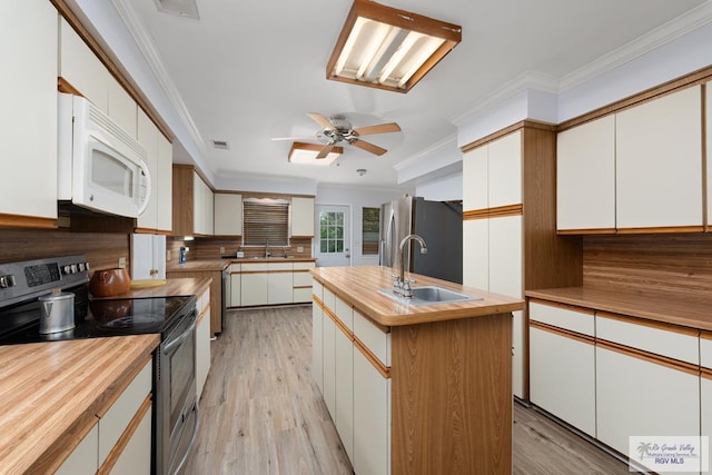 kitchen featuring sink, appliances with stainless steel finishes, a kitchen island with sink, white cabinets, and light wood-type flooring