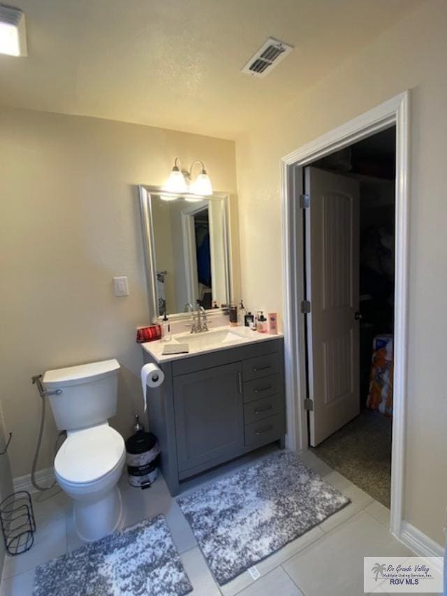 bathroom featuring tile patterned floors, vanity, and toilet