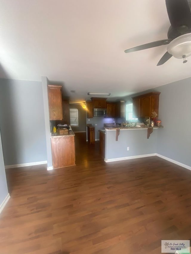 710 5th St Unit 5, Harlingen, TX 78550 - unfurnished living room featuring a ceiling fan and dark wood-style flooring