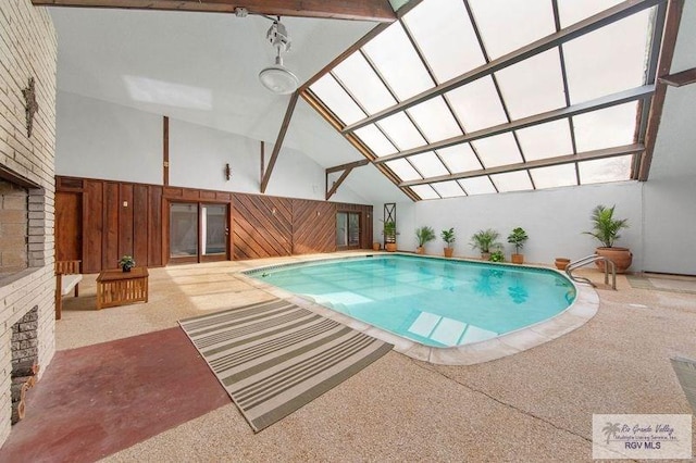 view of swimming pool with a hot tub and a brick fireplace